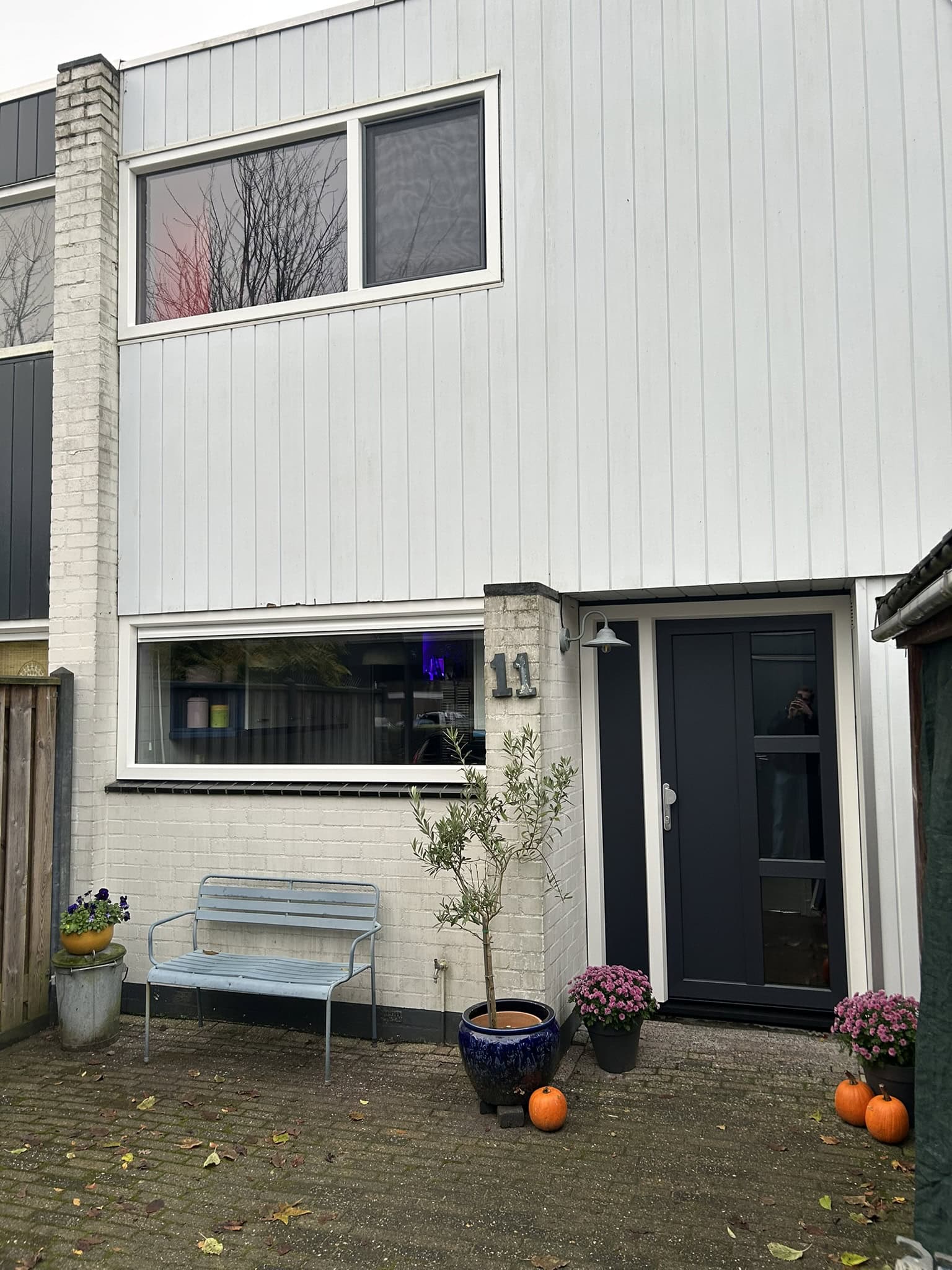 Voorgevel woning waarbij de kozijnen en voordeur zijn vervangen door kunststof kozijnen met houtnerf door C.H. Montage.